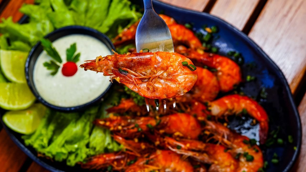 Succulent grilled shrimp served with creamy sauce and fresh lime for a flavorful meal.
